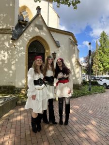 Piratinnen auf Abschlusskurs: Drei Schülerinnen des evdp präsentieren ihre Kostüme während der Mottowoche vor der Herforder Jakobi-Kirche.